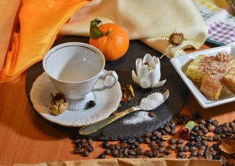 cup on the table between orange candies and sugar