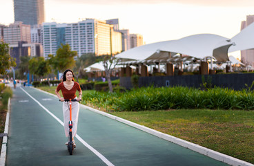 Woman riding electric scooter for transportation in a modern city