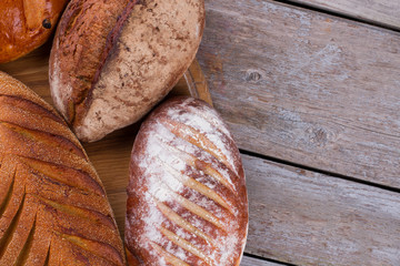Wholemeal bread on wooden background. Loaves of whole wheat bread and copy space.
