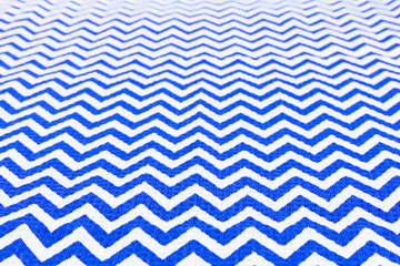 Blue and white fabric tablecloth zigzag pattern receding into the distance, Christmas and New Year...