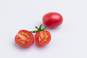 Grape or cherry tomato branch. Pile of red grape tomatoes isolated on white background, soft light, angle view, studio shot.
