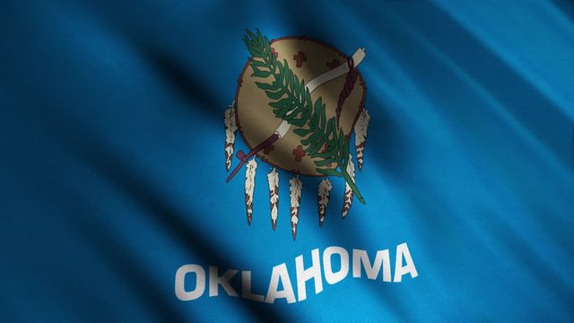 Close-up of waving Oklahoma flag. Animation. Patriotic background flag is rectangular blue color with image in center of Indian appliances. Flags of States of America