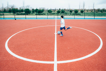 Soccer player boy hitting the ball
