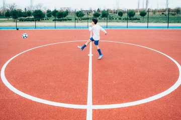 Soccer player boy hitting the ball