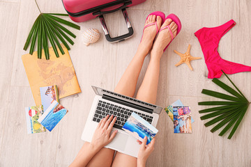 Obraz na płótnie Canvas Woman with laptop visiting travel agency website, top view