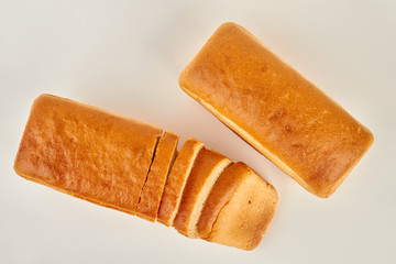 Bread on white background, top view. Whole and sliced loaves of bread. Fresh homemade product.