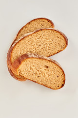 Slices of wheat bread, top view. Fresh whole grain bread cutted on white background.