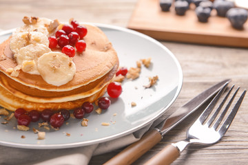 Plate with tasty sweet pancakes on table, closeup