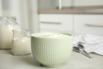 Tasty organic yogurt on grey table indoors