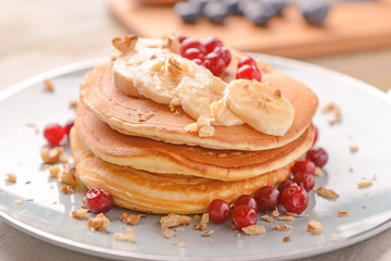 Plate with tasty sweet pancakes on table, closeup
