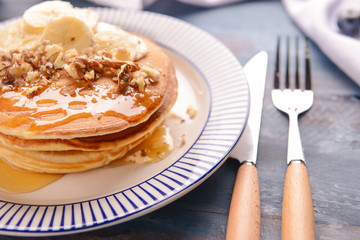 Plate with tasty sweet pancakes on table, closeup