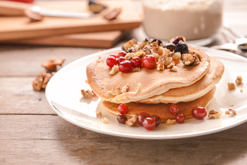 Plate with tasty sweet pancakes on table, closeup