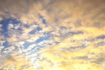 Sky with clouds with bright sunshine. Sunset. The sky is illuminated by sunlight at sunset..