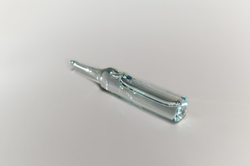 Single medical ampoule with vaccine on white backround
