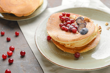 Plate with tasty sweet pancakes on table