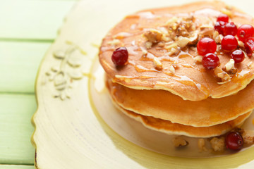 Plate with tasty sweet pancakes on table, closeup
