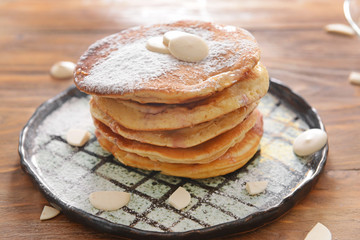 Plate with tasty sweet pancakes on table