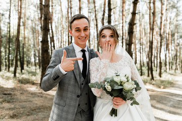 Attractive couple celebrating their wedding in forest. Portrait of young happy groom and bride in...