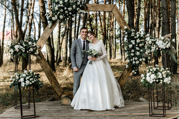 Attractive couple celebrating their wedding in forest. Portrait of young happy groom and bride in...