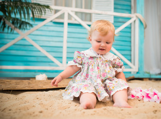 Charming smiling little girl in a floral dress
