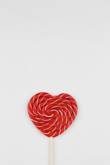 red heart as lollipop candy. Valentines day minimalist background. red heart, love symbol, space for text concept.