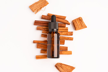 Aromatherapy scene with cinnamon aroma oil in glass bottle on white background, healthcare minimal...