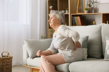 Senior woman suffering from back pain at home