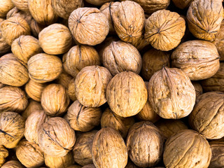 Inshell walnuts. Background made of nuts. Photowall-paper.