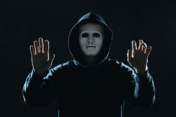 Professional hacker in mask on dark background