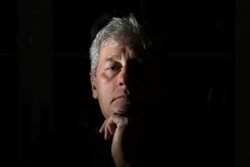 chiaroscuro portrait of a white-haired man