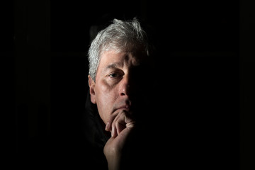 chiaroscuro portrait of a white-haired man