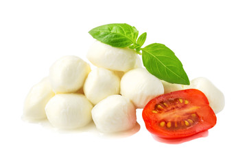 Heap of mini mozzarella cheese balls, basil and half of cherry tomato isolated on white background. Healhy mediterranean cuisine and vegetarian food.