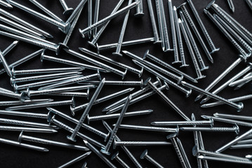 construction metal nails on black background