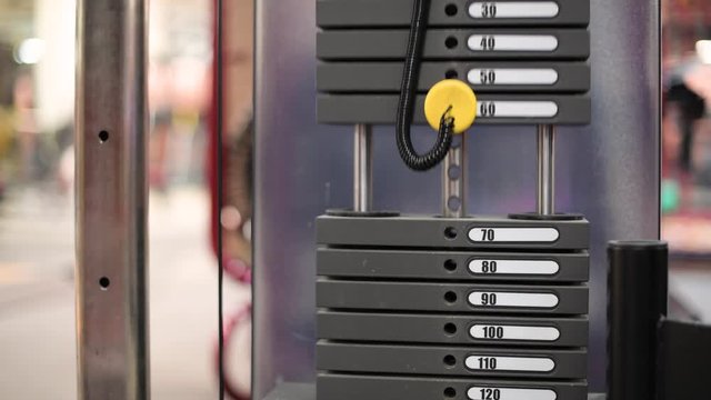 weighting blocks on a sports machine move up and down together with the effort of an athlete, no face