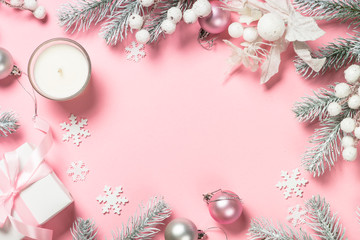Christmas present box and decorations on pink background.