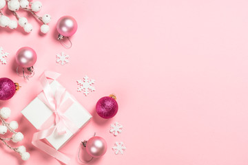 Christmas present box and decorations on pink background.