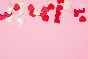 Red hearts for Valentine's day lie on a beautiful pink background. Heart pendant. Space for text....