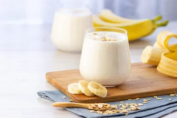 Fototapete Milchshake Vegan banana and oatmeal smoothie in glass jar on the light background. Healthy food.  © Dmitrii