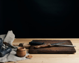 old sharp knife and sharpener with a handle on a wooden background