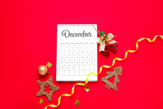 Calendar with page of December and Christmas decor on color background