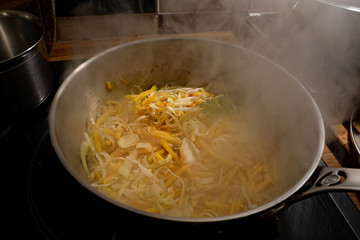 Cooking a wok vegetable with carrot, onions and cabbage