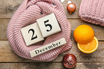 Calendar with date of Christmas on wooden background