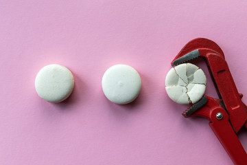 Broken, squeezed, crushed with a wrench macaroon cake in comparison with other whole. Concept of a broken soul under the pressure of circumstances, violence, psychological trauma