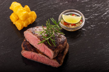 slices of grilled steak on black slate