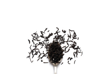 Loose leaf black tea sprinkled on a silver spoon and white background. View from above.