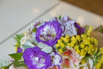 coloured macro photo of a detailed bouquet with pink roses, white small flowers and a fake diamond in the centre of the rose