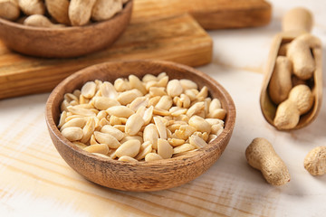 Plate with peanuts on white table