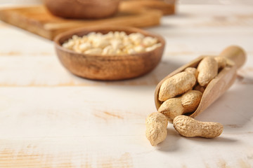 Scoop with peanuts on white table