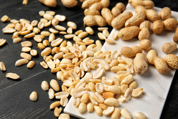 Board with peanuts on dark background