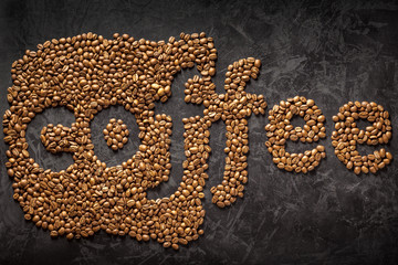 creative inscription coffee beans sprinkled on a black concrete surface
